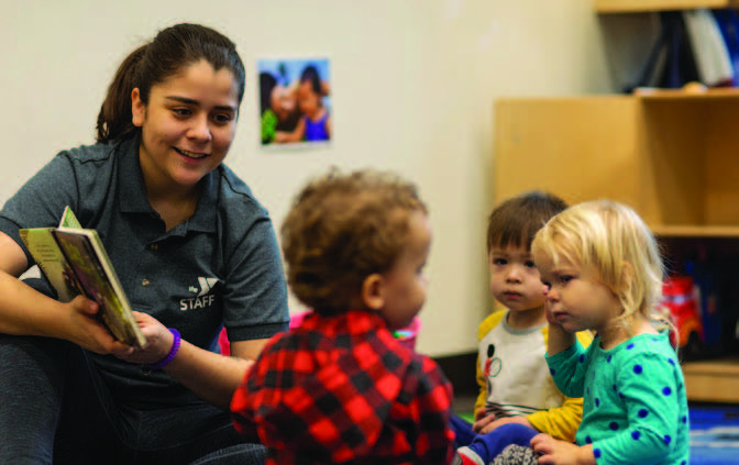 YMCA staff reading to children during child care program YMCA staff reading to children during child care program