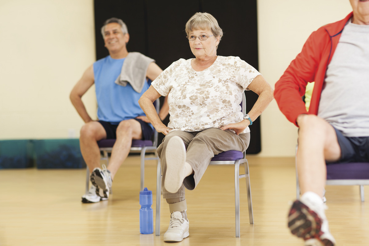 Older woman performing leg exercise at YMCA Louisville Forever Young fitness class Older woman performing leg exercise at YMCA Louisville Forever Young fitness class
