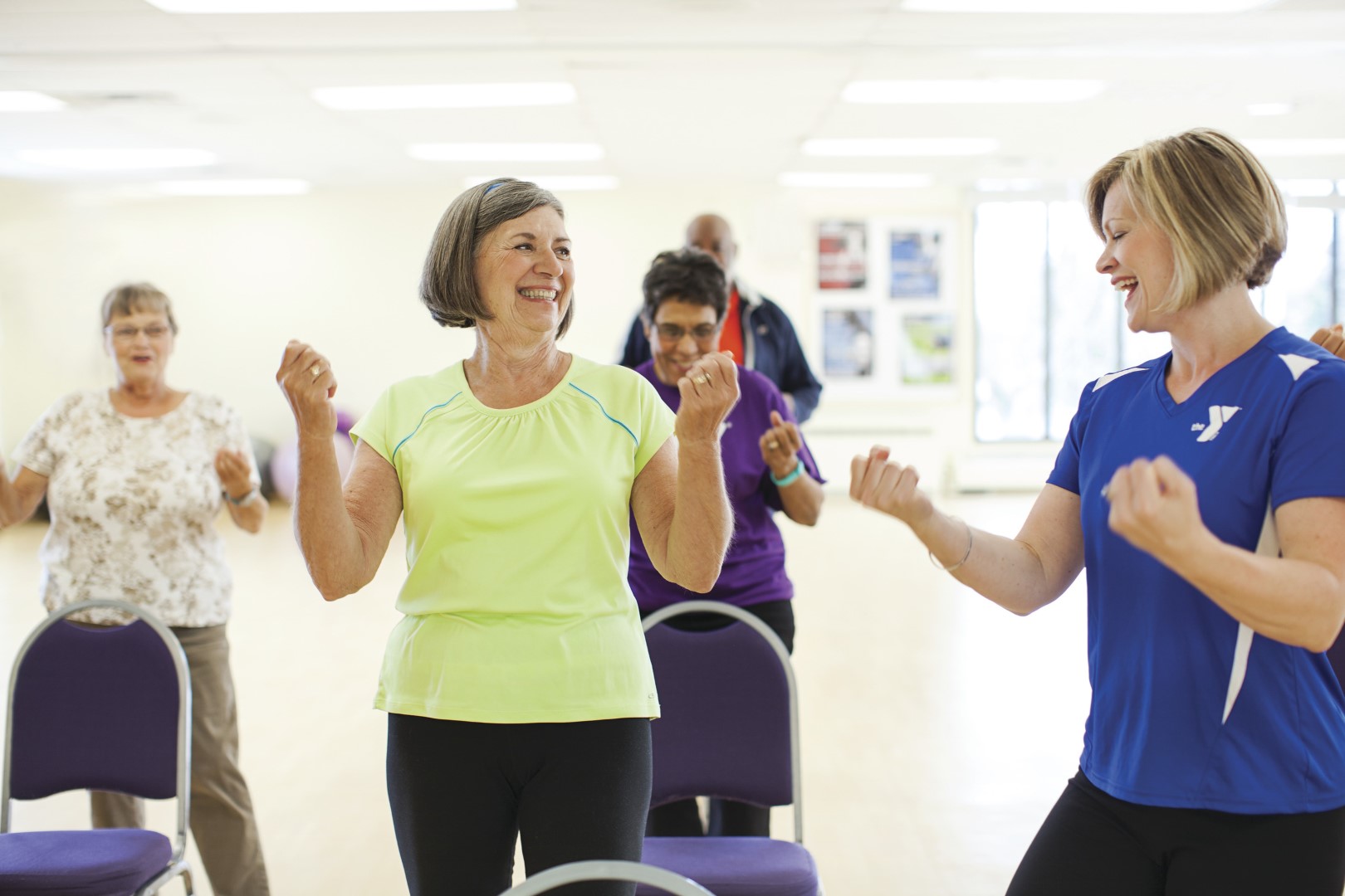 Adults and instructor flexing at group dance class at YMCA Louisville Adults and instructor flexing at group dance class at YMCA Louisville
