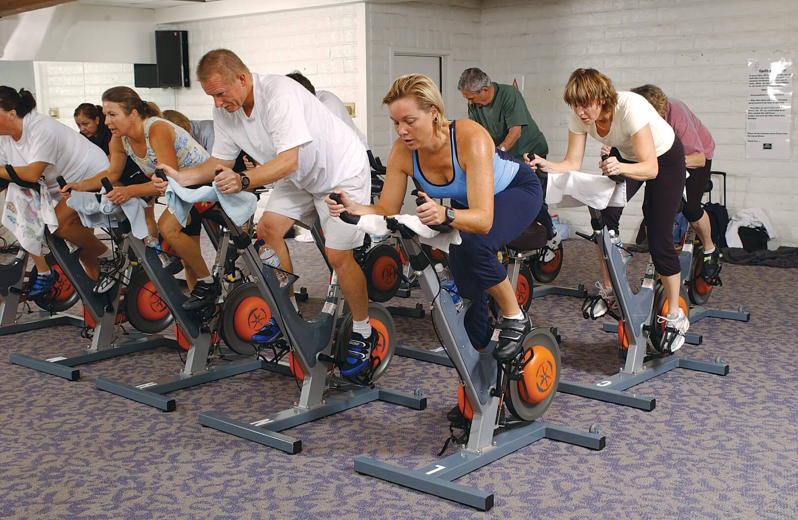 Adults in group fitness cardio class on exercise bikes at YMCA Louisville Adults in group fitness cardio class on exercise bikes at YMCA Louisville