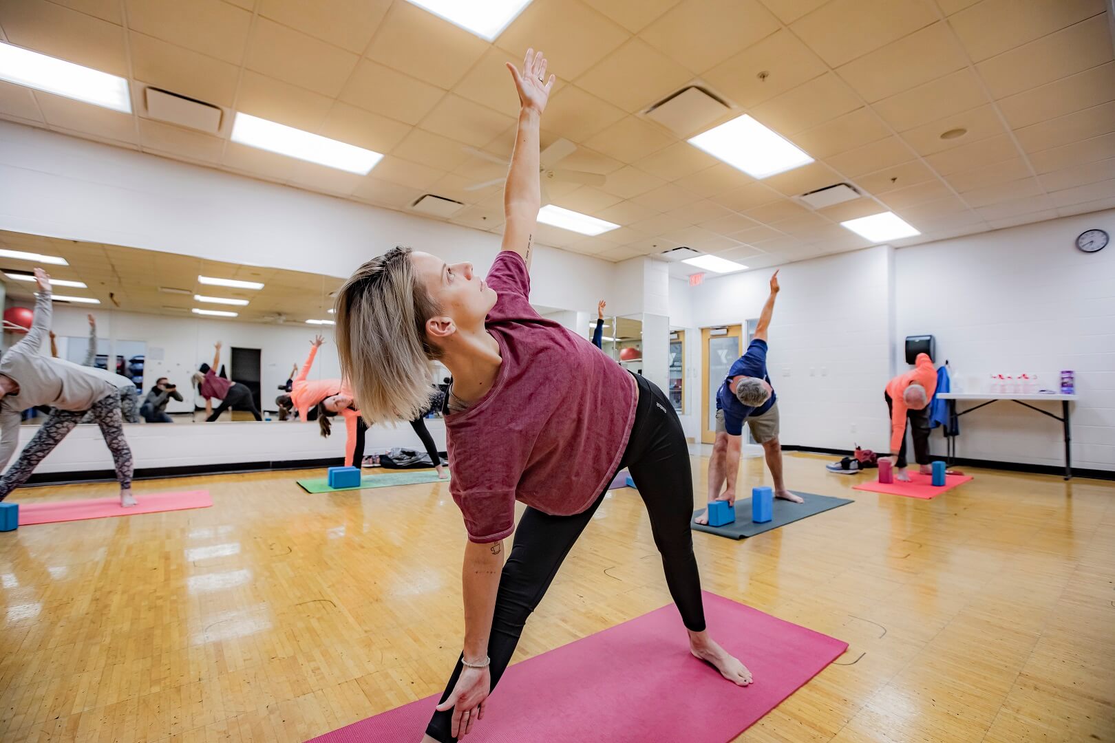 Adults doing yoga pose at group mind and body class at YMCA Louisville Adults doing yoga pose at group mind and body class at YMCA Louisville