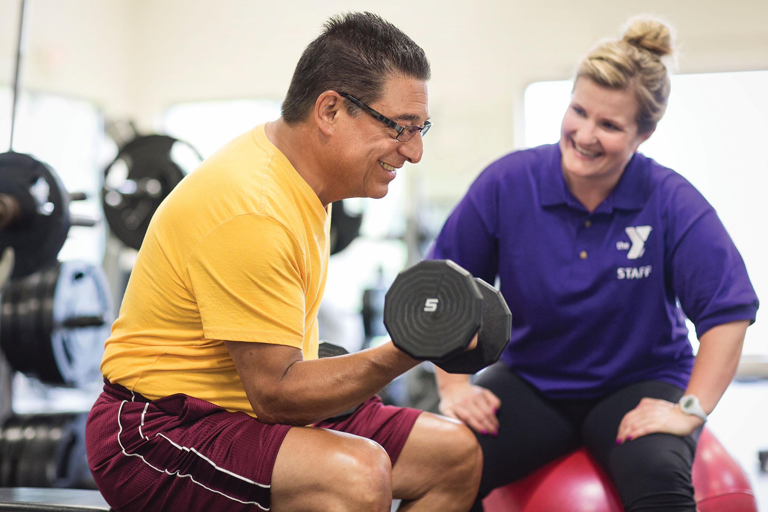 Person lifting weights during Smart Start fitness program at YMCA Louisville Person lifting weights during Smart Start fitness program at YMCA Louisville