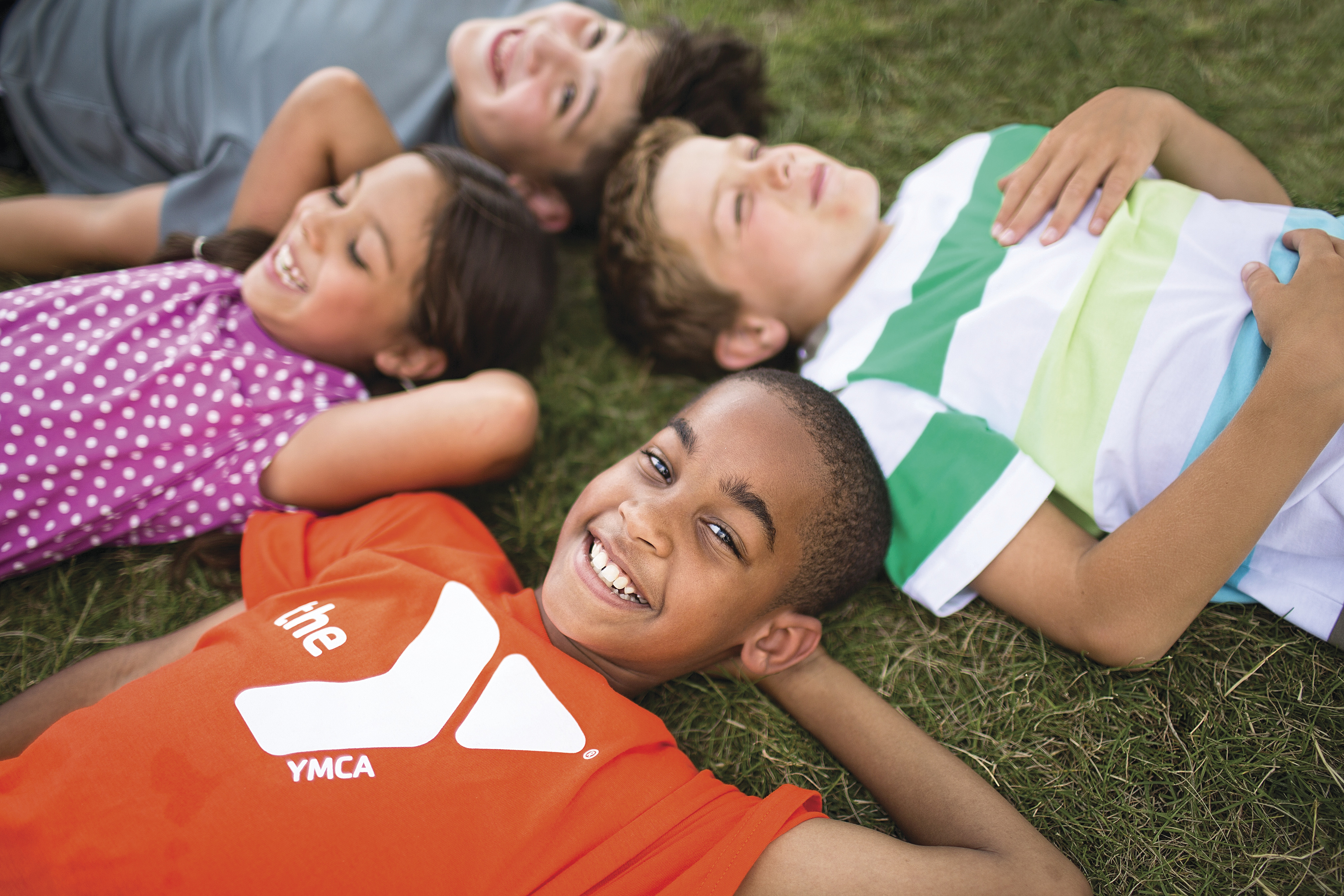 Group of kids laying on the ground looking at clouds Group of kids laying on the ground looking at clouds
