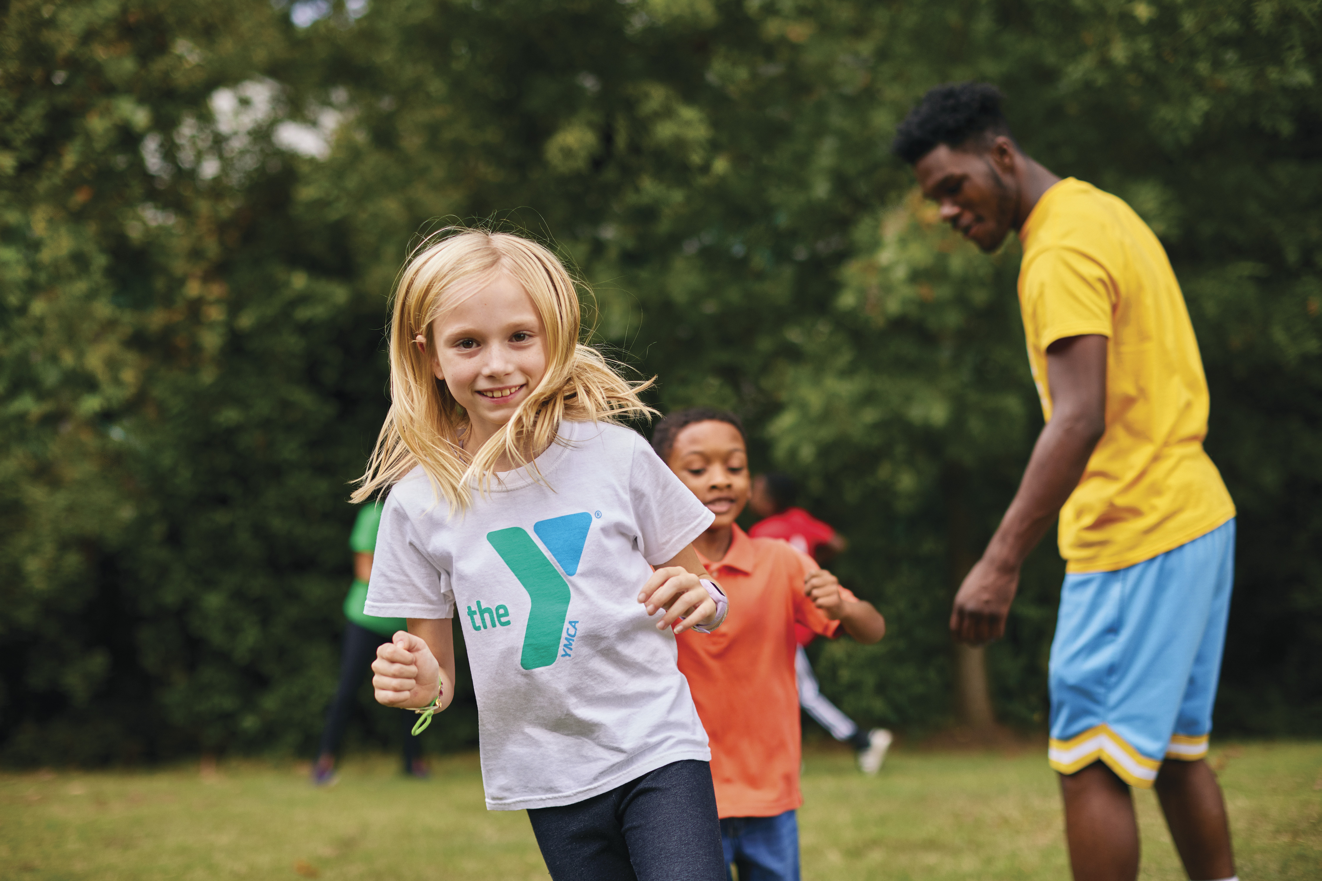 Smiling girl in YMCA shirt running outdoors Smiling girl in YMCA shirt running outdoors