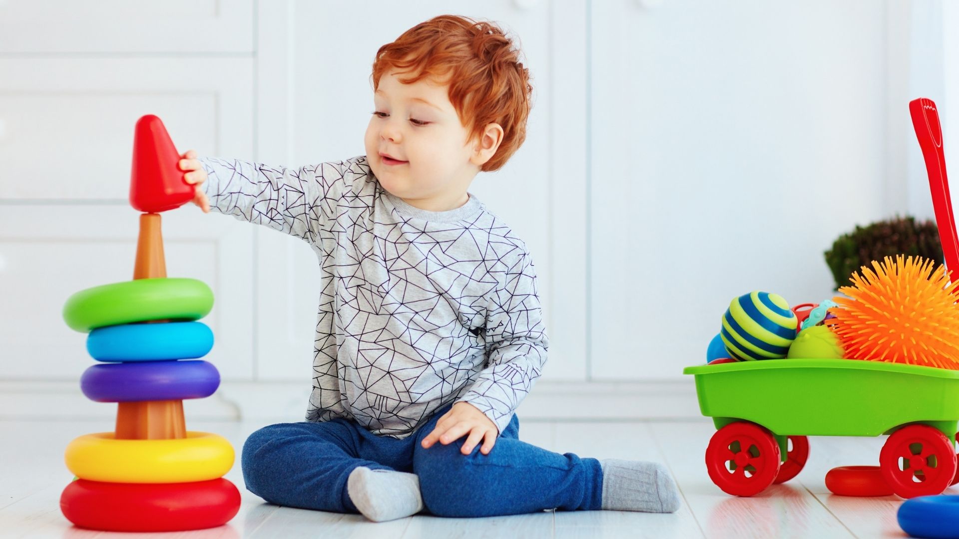 Toddler playing a game stacking rings on a cone Toddler playing a game stacking rings on a cone