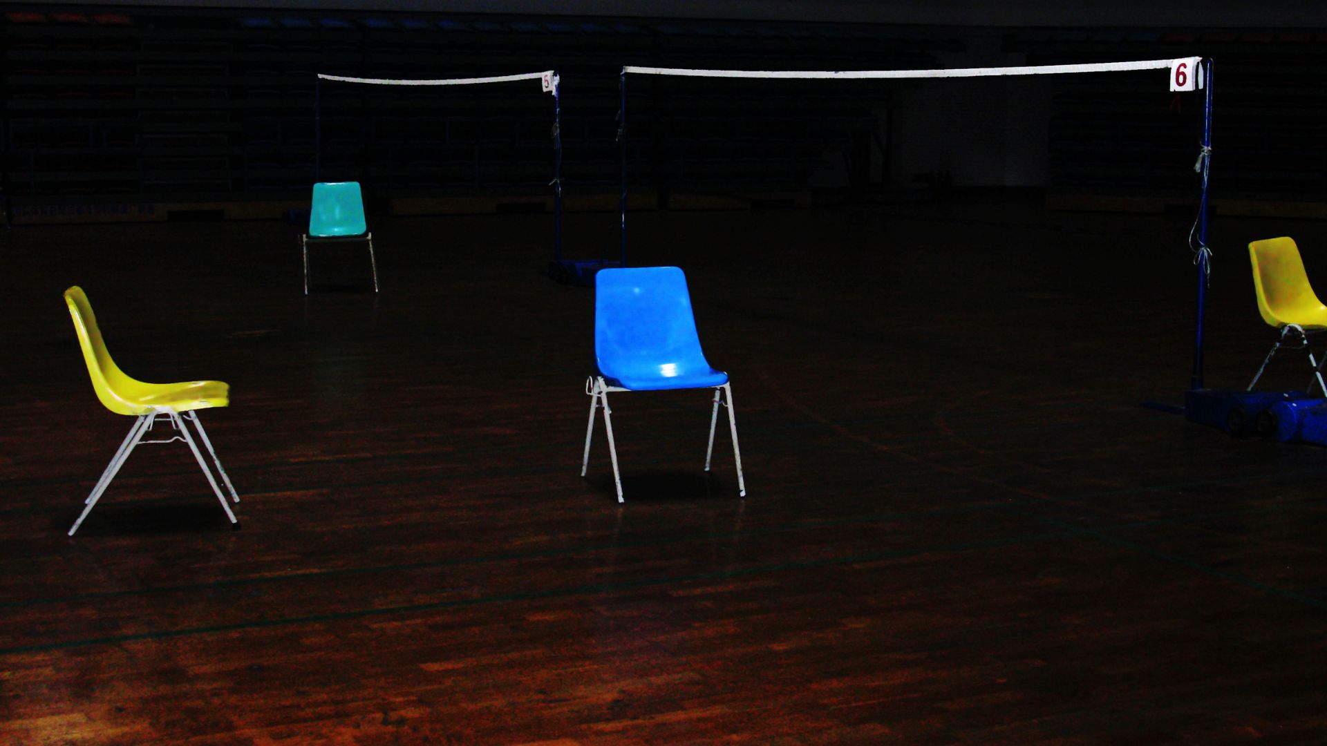 Chairs set up in front of volleyball net Chairs set up in front of volleyball net