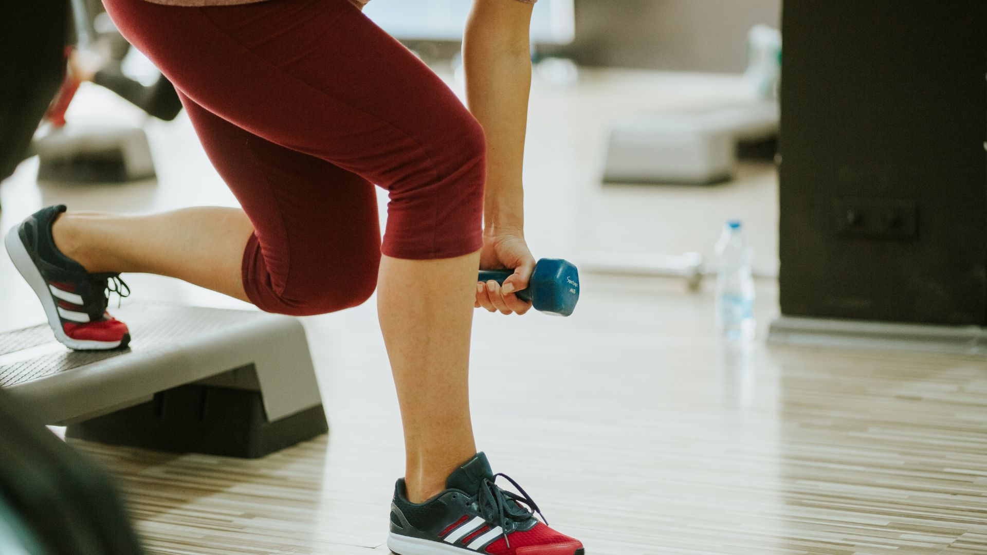 Person lifting a handweight on a workout step Person lifting a handweight on a workout step