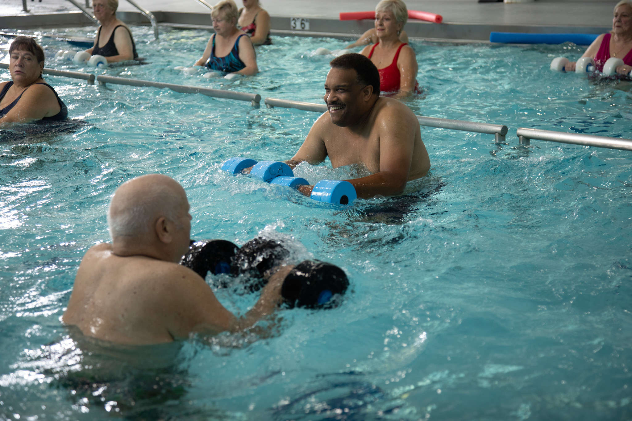 Group of people exercising at the pool Group of people exercising at the pool