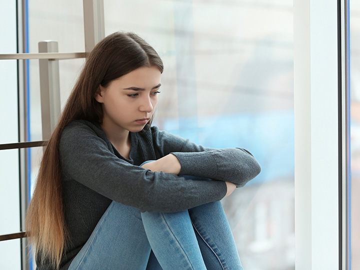 Girl sitting at a hallway looking sad Girl sitting at a hallway looking sad