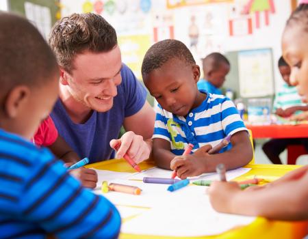 YMCA staff coloring with kids at YMCA child care program YMCA staff coloring with kids at YMCA child care program