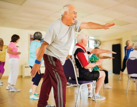 Older man stretching at mind and body class at YMCA Louisville Older man stretching at mind and body class at YMCA Louisville