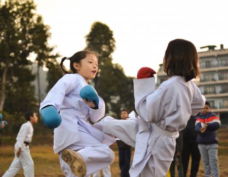 Two young children sparring outdoors Two young children sparring outdoors