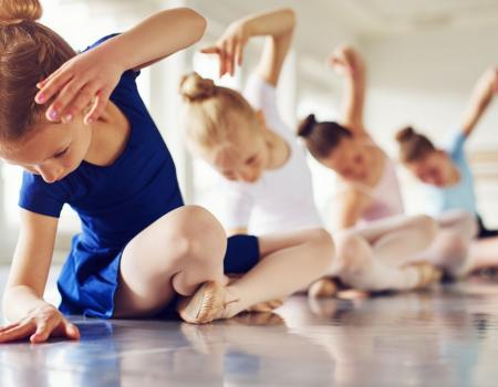 Girls sitting on floor in ballet pose in ballet outfits Girls sitting on floor in ballet pose in ballet outfits
