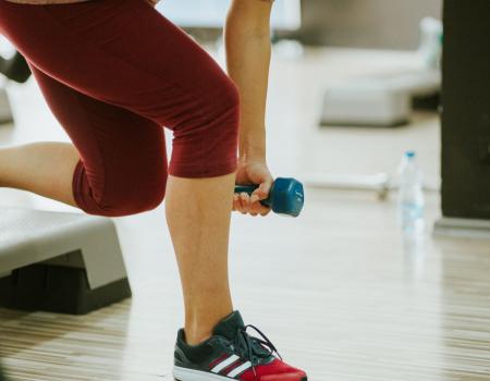 Person lifting a handweight on a workout step Person lifting a handweight on a workout step