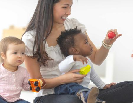 Adult with 3 young kids in a YMCA childcare program Adult with 3 young kids in a YMCA childcare program