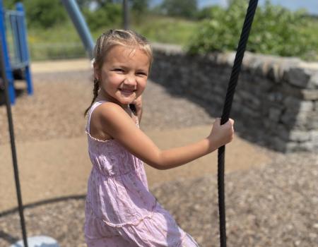 Girl smiling and swinging at park outside Girl smiling and swinging at park outside