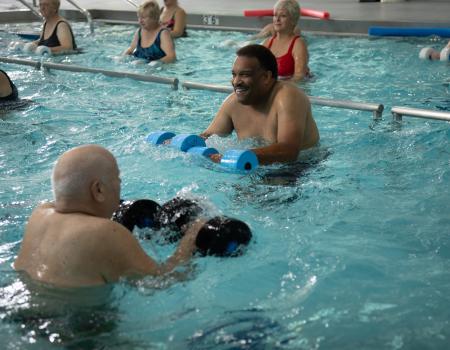 Group of people exercising at the pool Group of people exercising at the pool